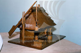 Miniature wooden house and a well